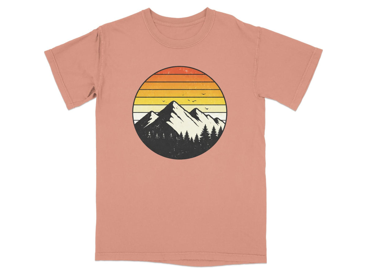 T-shirt with circular mountain and tree graphic with sunset colors.