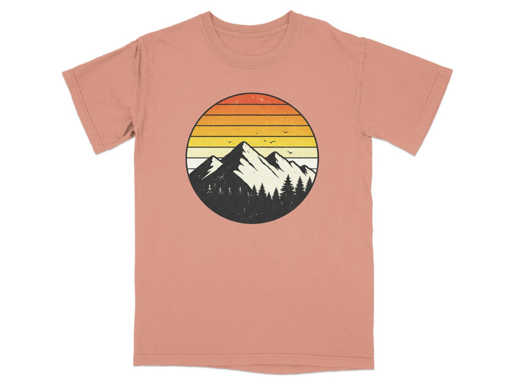 T-shirt with circular mountain and tree graphic with sunset colors.
