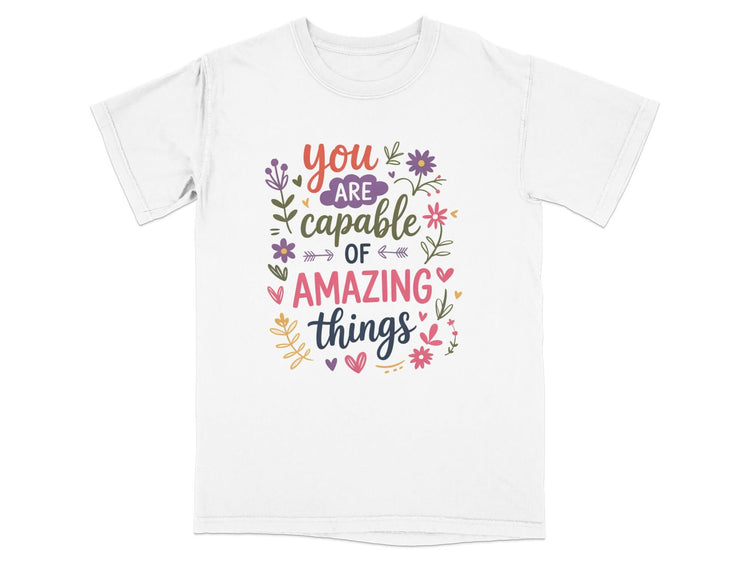White t-shirt with "You are capable of amazing things" text and floral graphics.