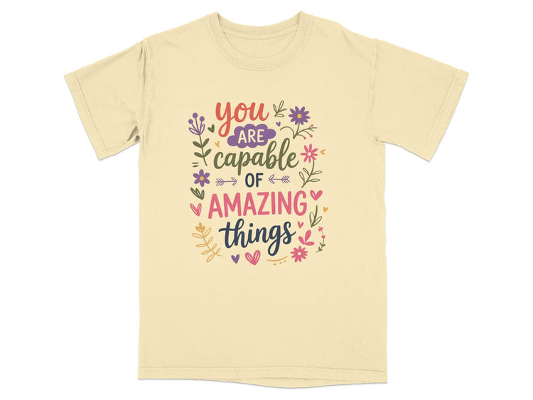 Light yellow t-shirt with "you are capable of amazing things" text design.