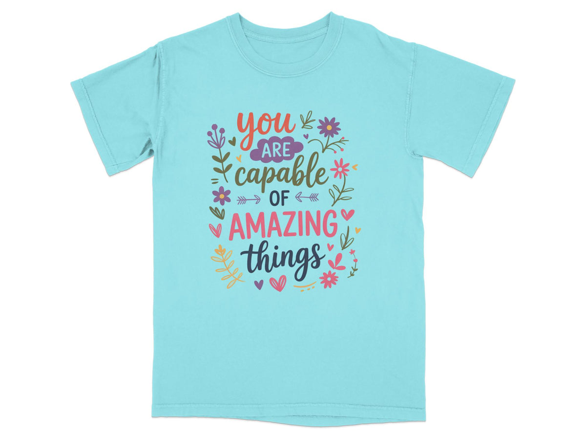 Teal t-shirt with "you are capable of amazing things" text and floral design.
