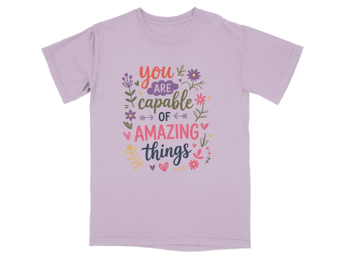 Purple t-shirt with "You are capable of amazing things" text and floral design.
