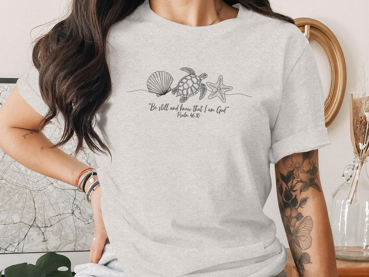 T-shirt with seashell, starfish, and turtle line art and Psalm 46:10 quote.