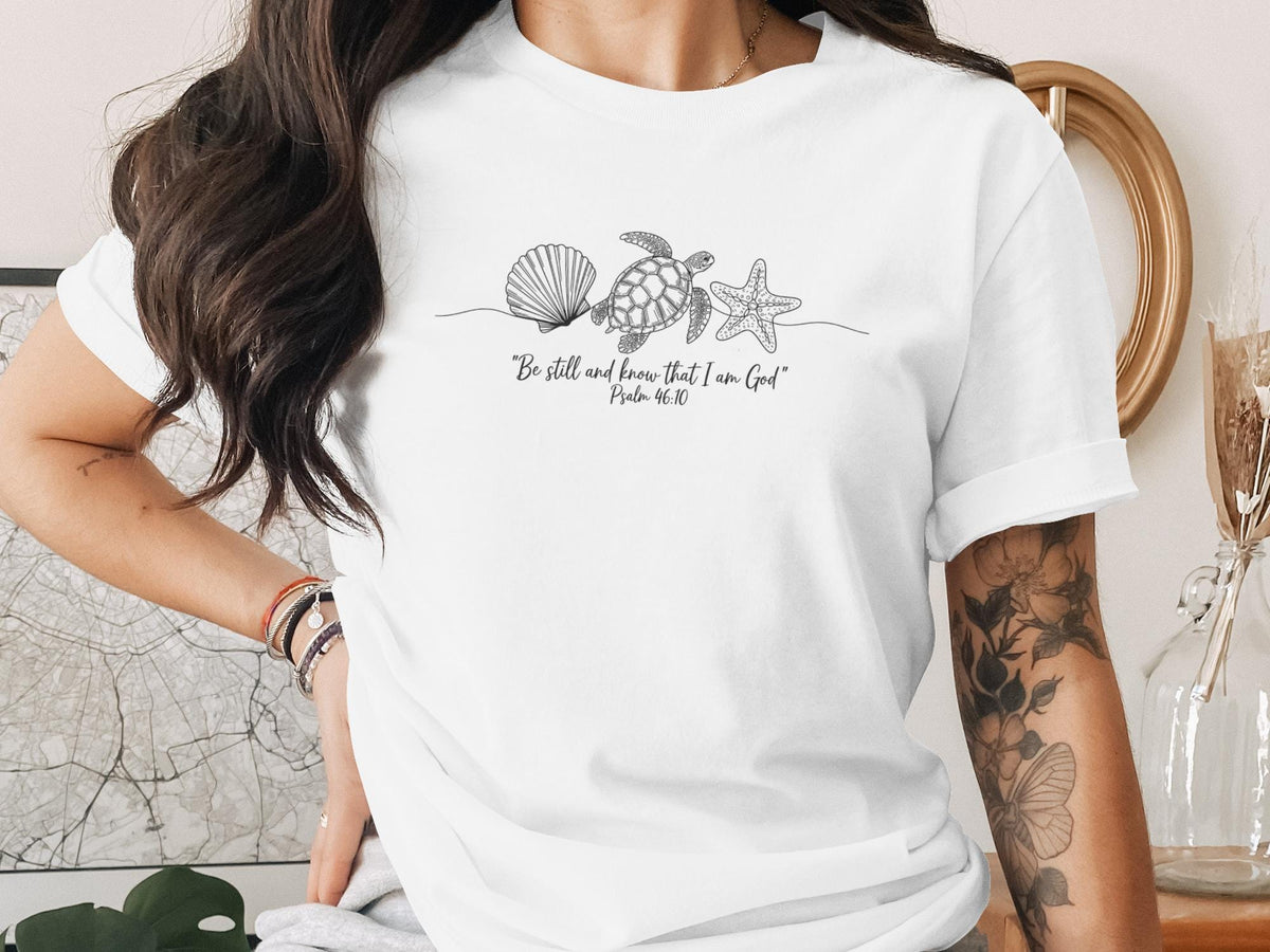White t-shirt with minimalist line art of seashell, starfish, and turtle.