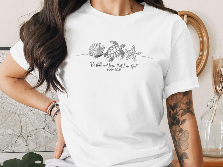 White t-shirt with minimalist line art of seashell, starfish, and turtle.