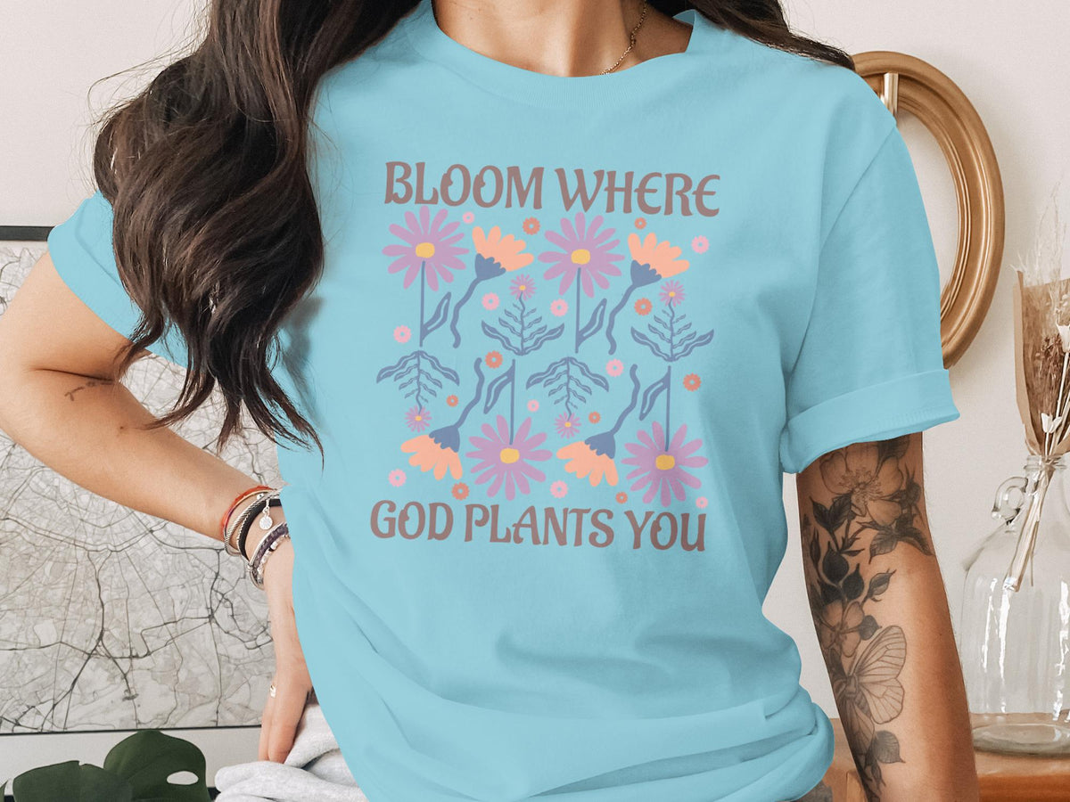 Light blue t-shirt with "Bloom Where God Plants You" text and floral graphic.