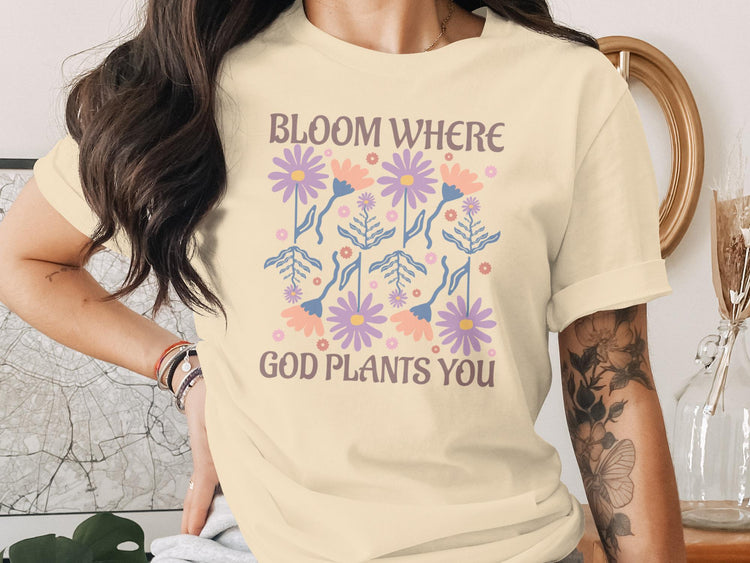 Cream t-shirt with floral design and "Bloom Where God Plants You" text.