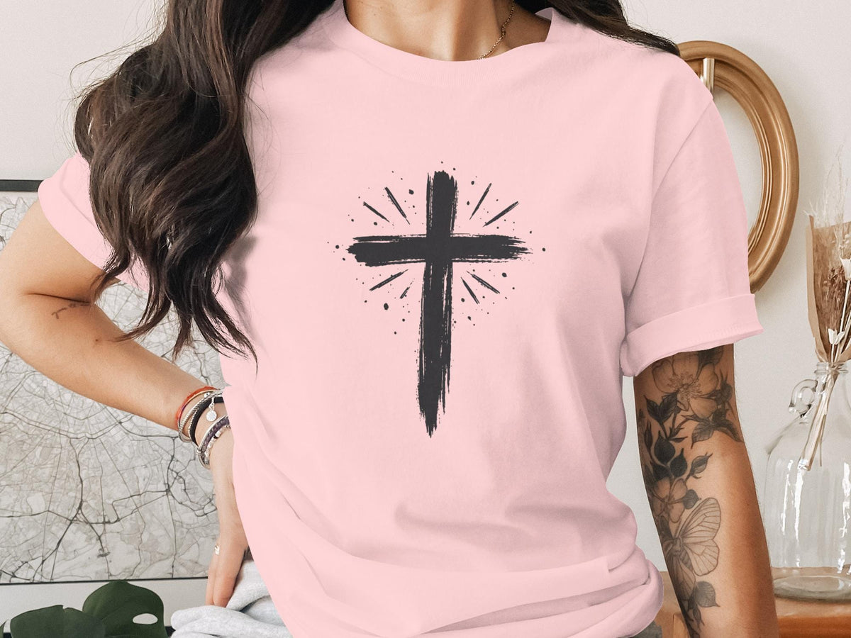 Pink t-shirt with black hand-painted cross design and radiating lines.