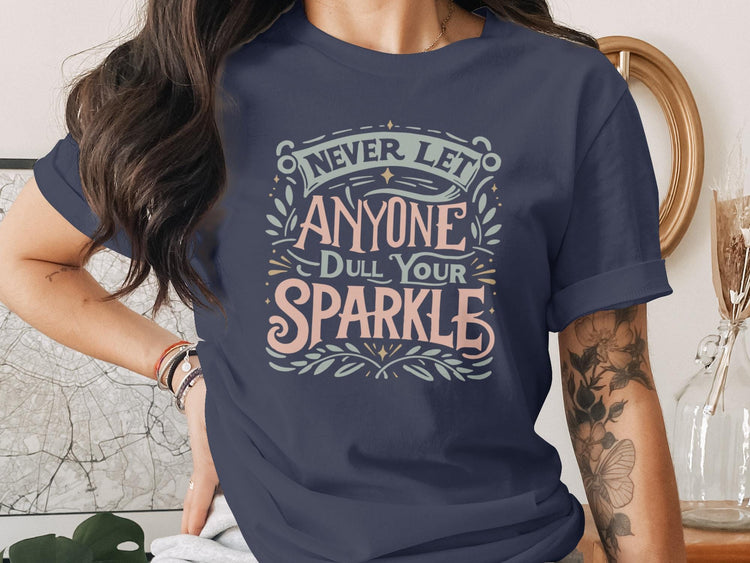 Navy t-shirt with "Never Let Anyone Dull Your Sparkle" text design.