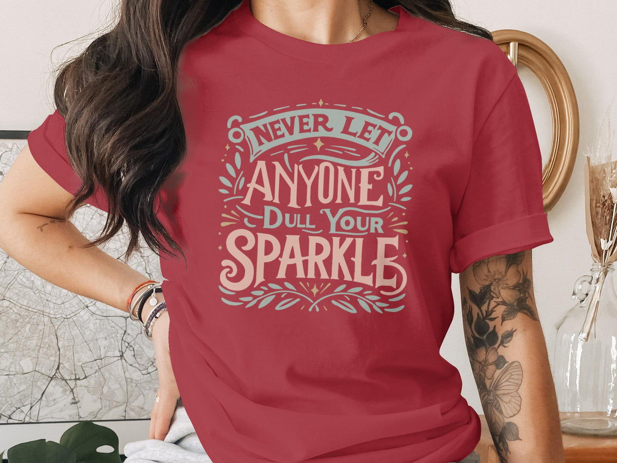 Red t-shirt with "Never Let Anyone Dull Your Sparkle" text and decorative elements.
