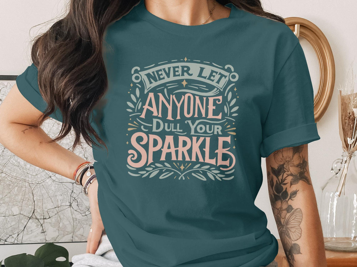 Teal t-shirt with "Never Let Anyone Dull Your Sparkle" text.