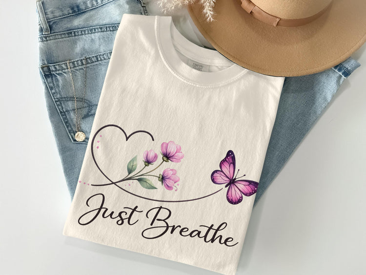 White t-shirt with a pink butterfly and flowers design and "Just Breathe" text.