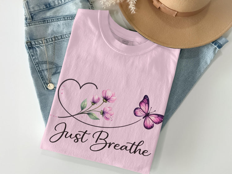 Pink t-shirt with butterfly and floral design, "Just Breathe" text.