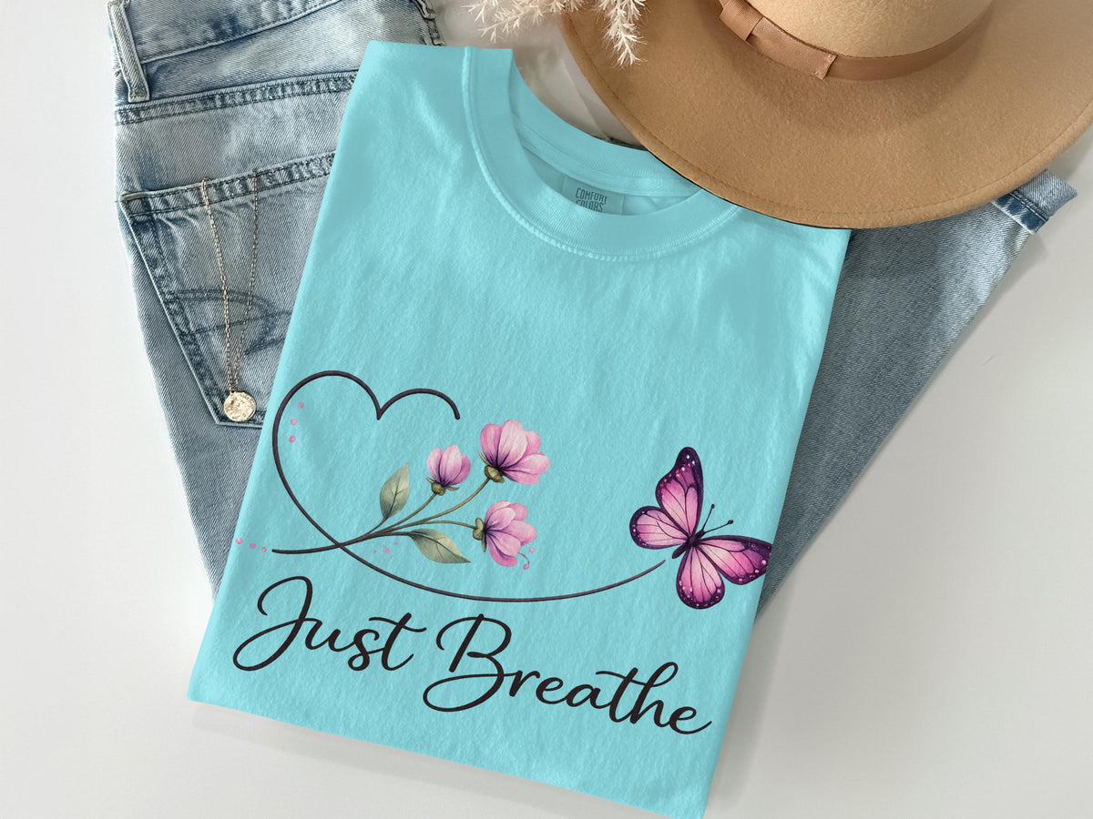 Light blue t-shirt with pink butterfly and "Just Breathe" text.