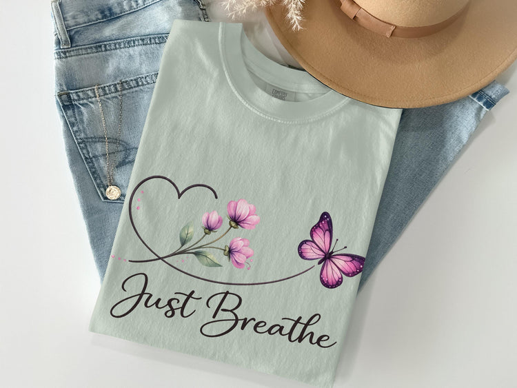 Light mint t-shirt with butterfly, flowers, and "Just Breathe" text.