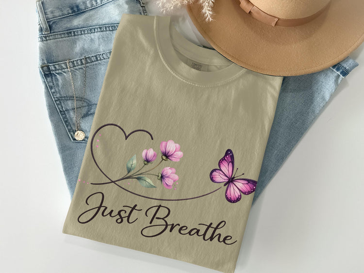 Tan t-shirt with purple butterfly, flowers, and "Just Breathe" text.