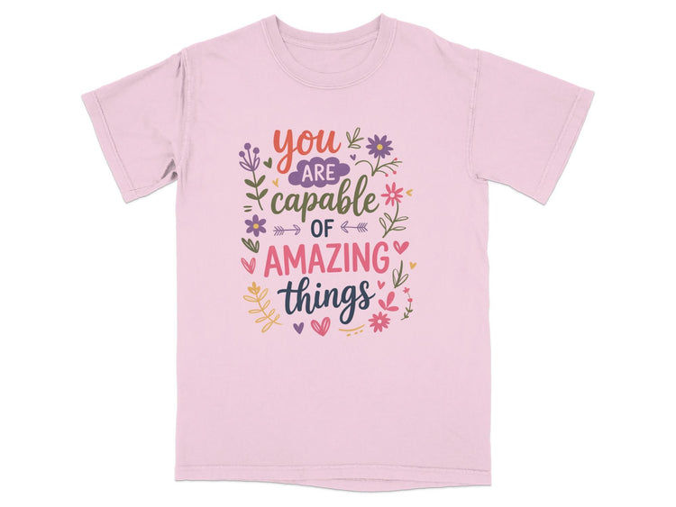 Pink t-shirt with "You Are Capable Of Amazing Things" text and floral designs.