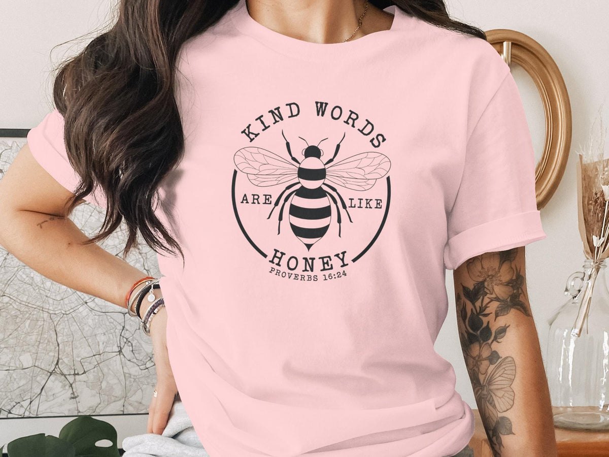 Pink t-shirt with a graphic of a bee and text "Kind words are like honey Proverbs 16:24".