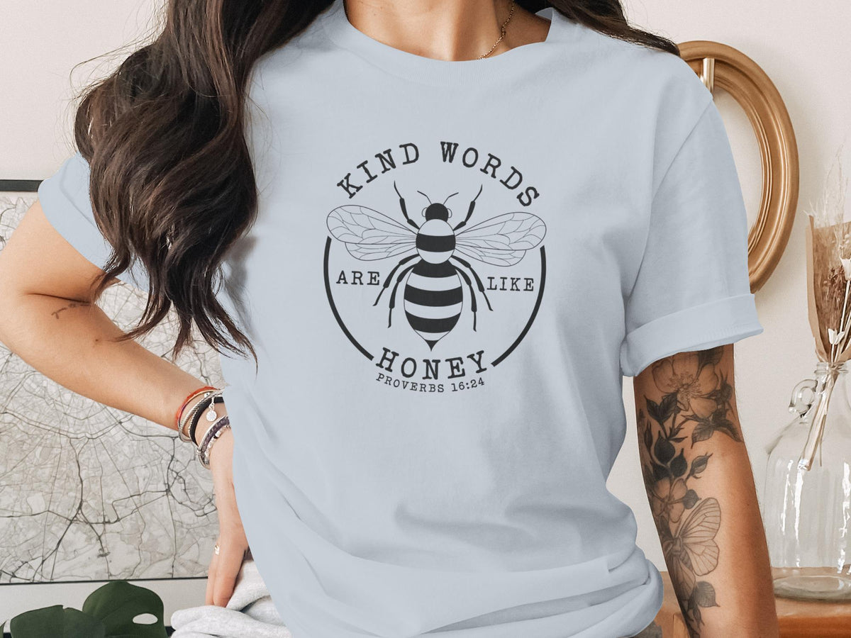 Light blue t-shirt with a circular graphic of a bee and the text "Kind words are like honey Proverbs 16:24."