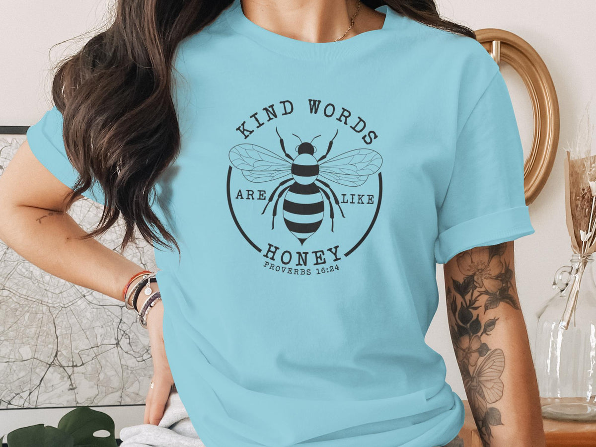 Light blue t-shirt with a bee graphic and the text "Kind words are like honey. Proverbs 16:24."