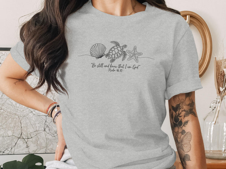 Grey t-shirt with seashells, starfish, and scripture.