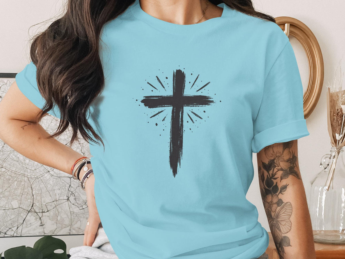 Light blue t-shirt with a black distressed cross design and radiating lines.
