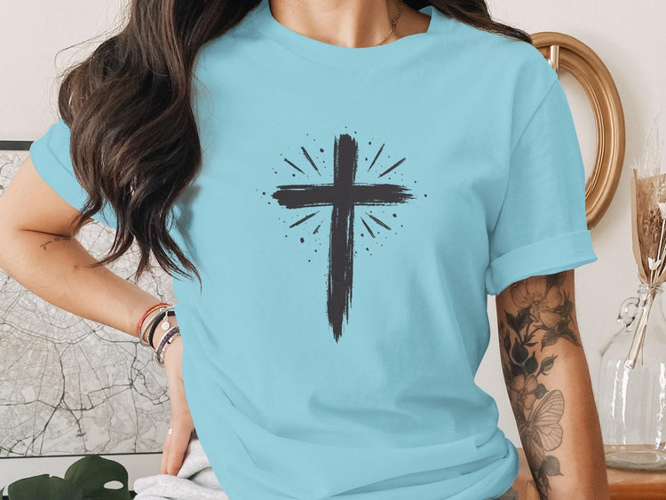 Light blue t-shirt with a black distressed cross design and radiating lines.