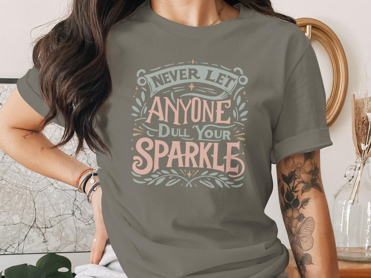 Gray t-shirt with "Never Let Anyone Dull Your Sparkle" text design.