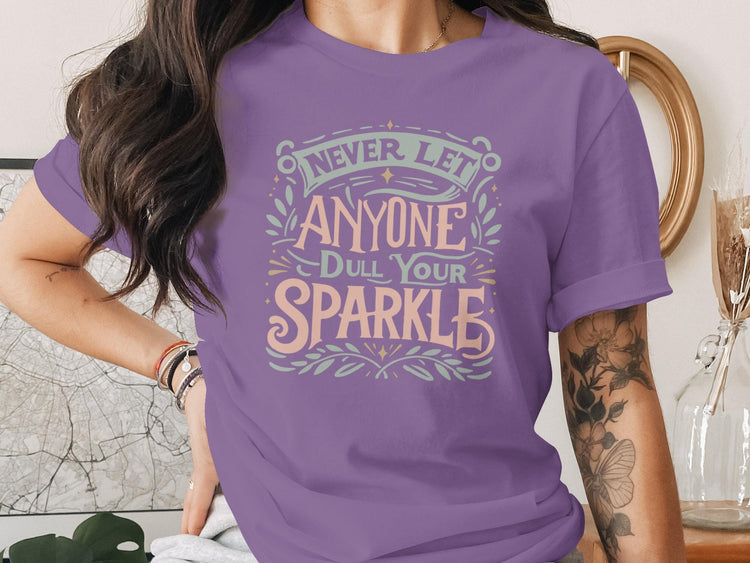 Purple t-shirt with "Never let anyone dull your sparkle" text design.