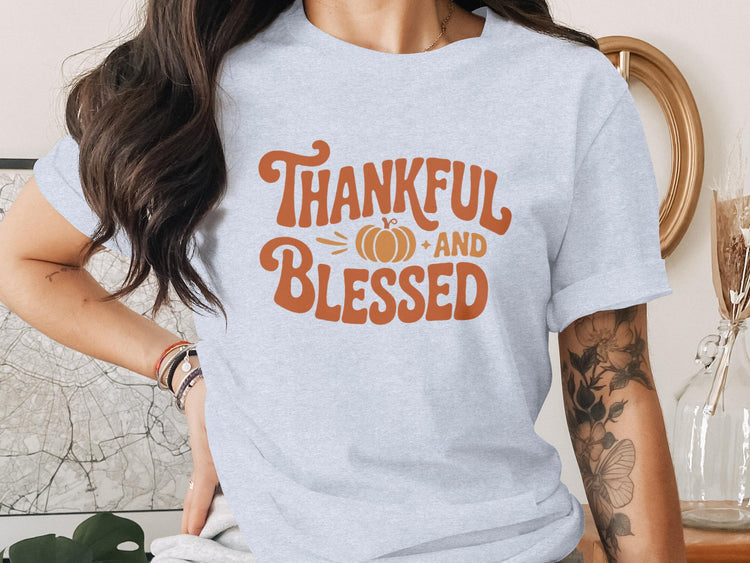 Light grey t-shirt with orange graphic "Thankful and Blessed" and pumpkin.