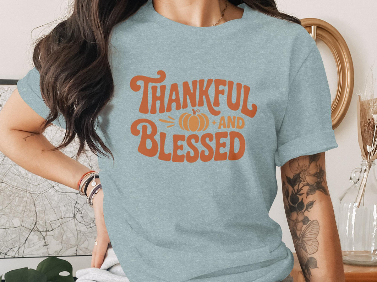 Light blue t-shirt with orange "Thankful and Blessed" text and pumpkin graphic.