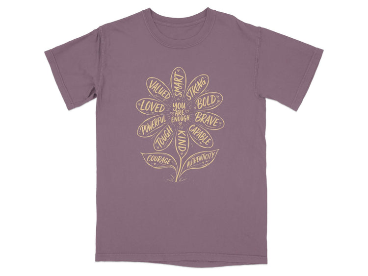 Purple t-shirt with a flower graphic listing positive affirmations like "loved," "strong," and "brave."