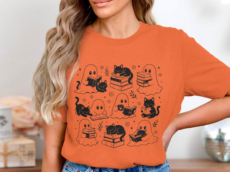 T-shirt with black line art of ghosts and cats reading books, themed for Halloween.