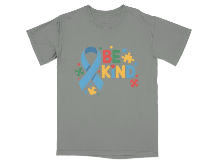 Grey t-shirt with "BE KIND" text and autism awareness ribbon with puzzle pieces.