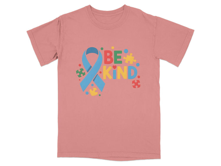 Pink t-shirt with "BE KIND" text and autism awareness ribbon and puzzle pieces.