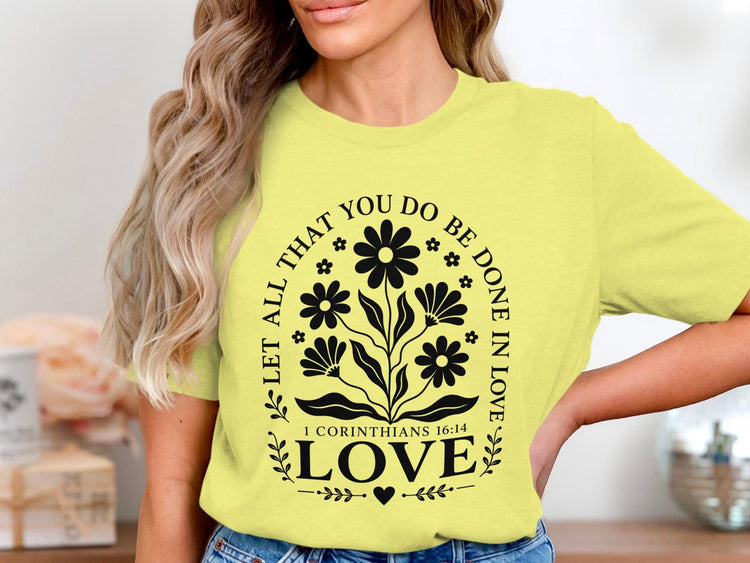 Yellow t-shirt with black floral design and text "Let all that you do be done in love."