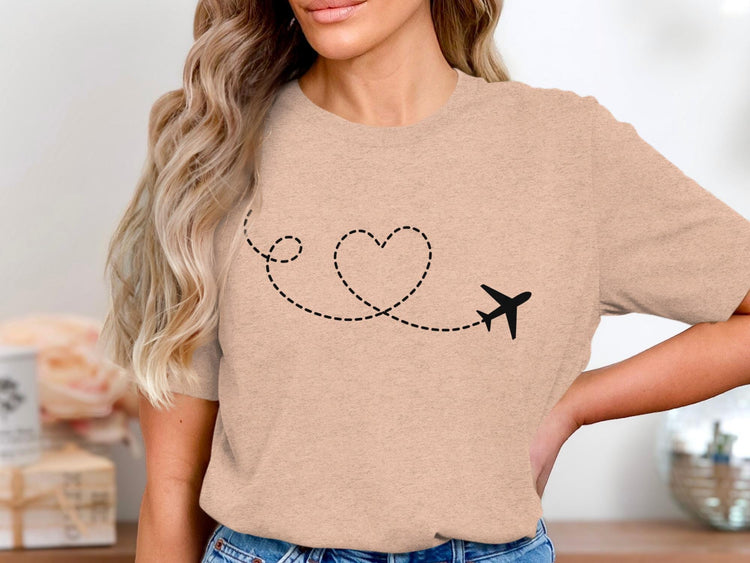 Peach t-shirt with black airplane and dashed heart trail graphic.