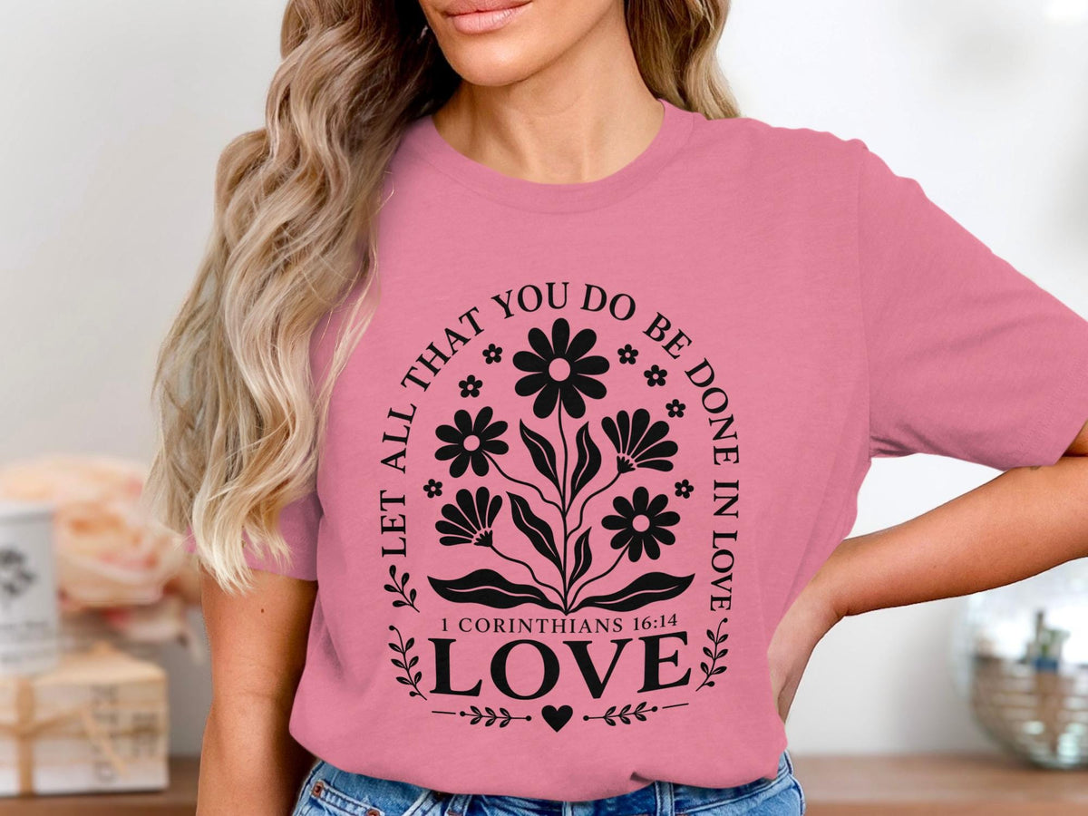Pink t-shirt with black floral design and text "Let all that you do be done in love".