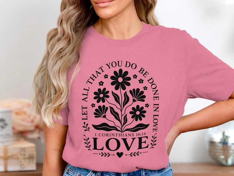 Pink t-shirt with black floral design and text "Let all that you do be done in love".