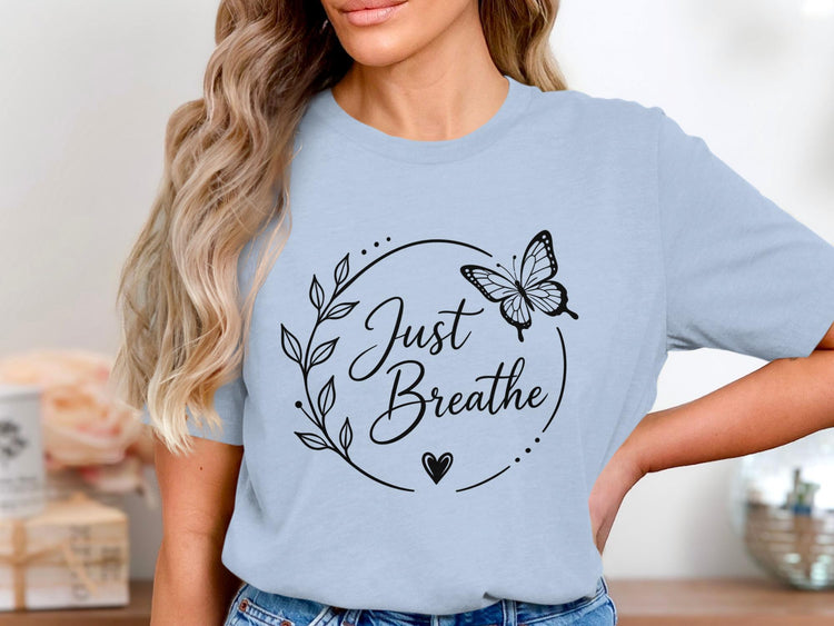 Light blue t-shirt with black floral design, butterfly, and "Just Breathe" text.