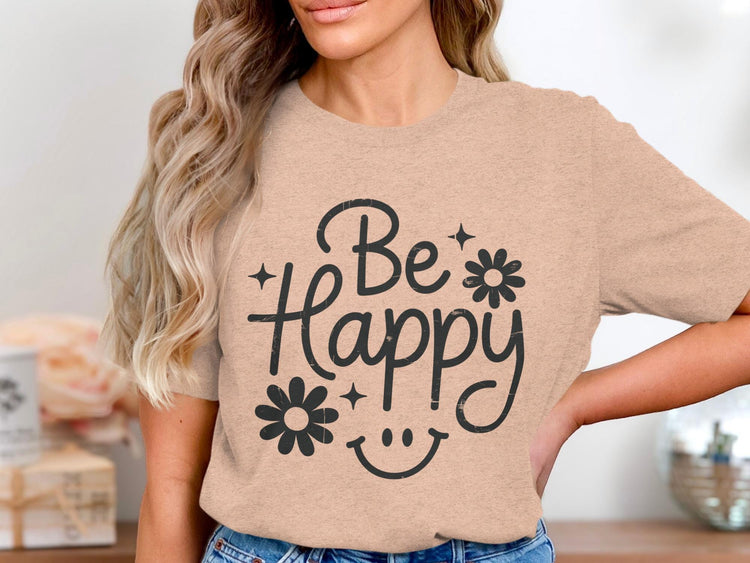 Peach t-shirt with "Be Happy" text, flowers, and smiley face graphic.