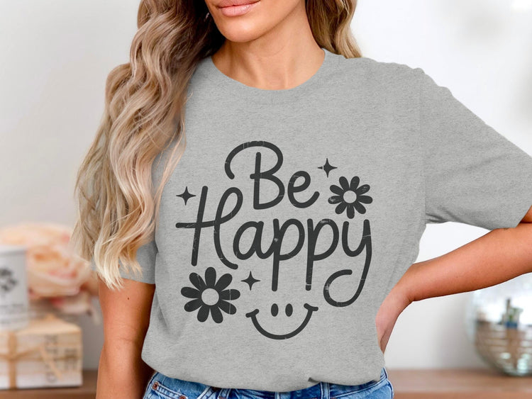 Grey t-shirt with "Be Happy" text, flowers, stars, and smiley face graphic.