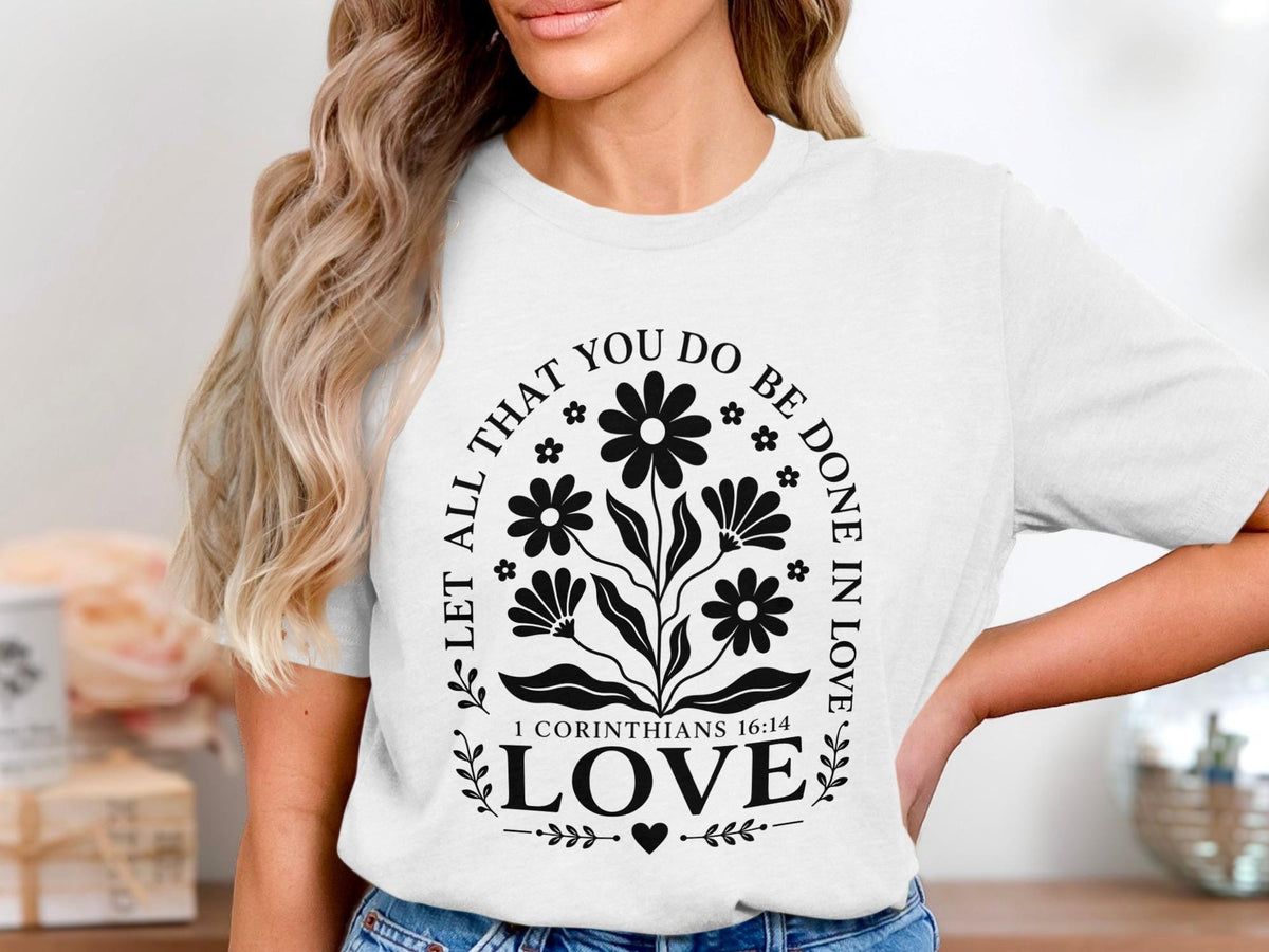 White t-shirt with floral design and text: "Let all that you do be done in love. 1 Corinthians 16:14 LOVE."
