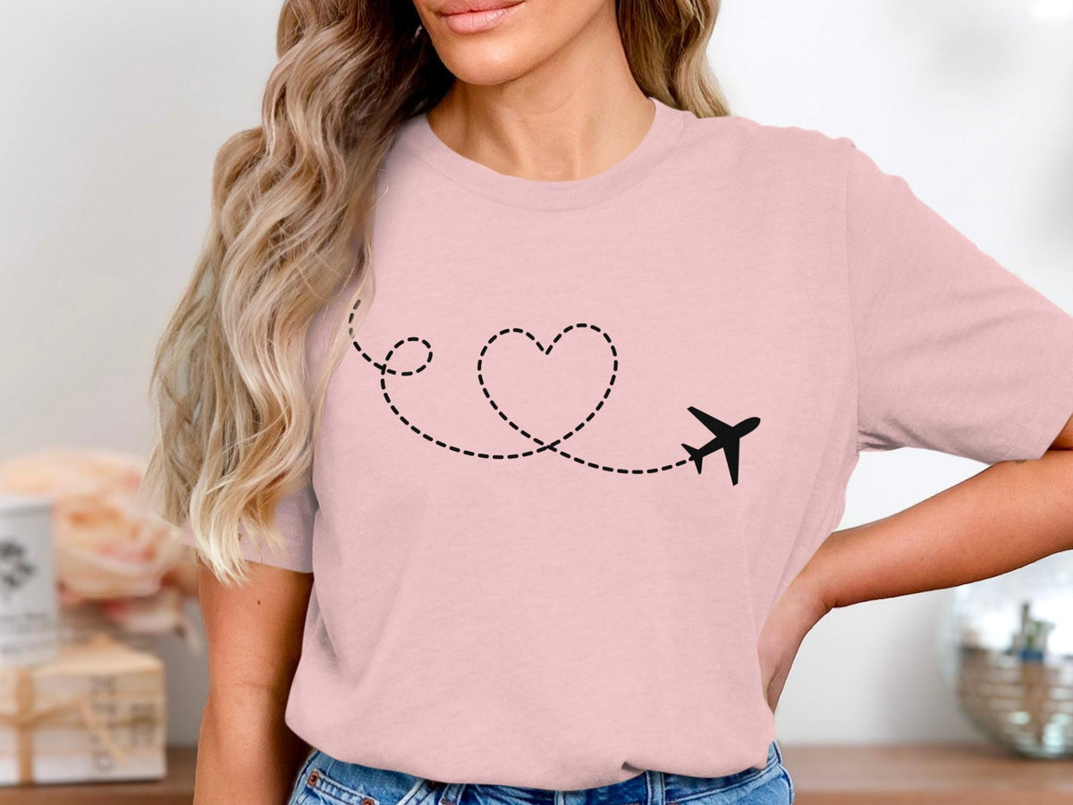 Pink t-shirt with black airplane and dotted line forming a heart.