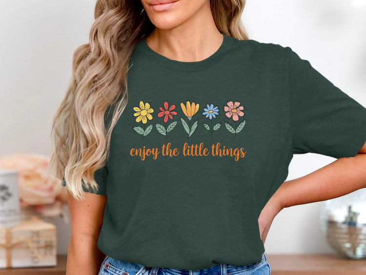Dark green t-shirt with colorful flowers and text "enjoy the little things".
