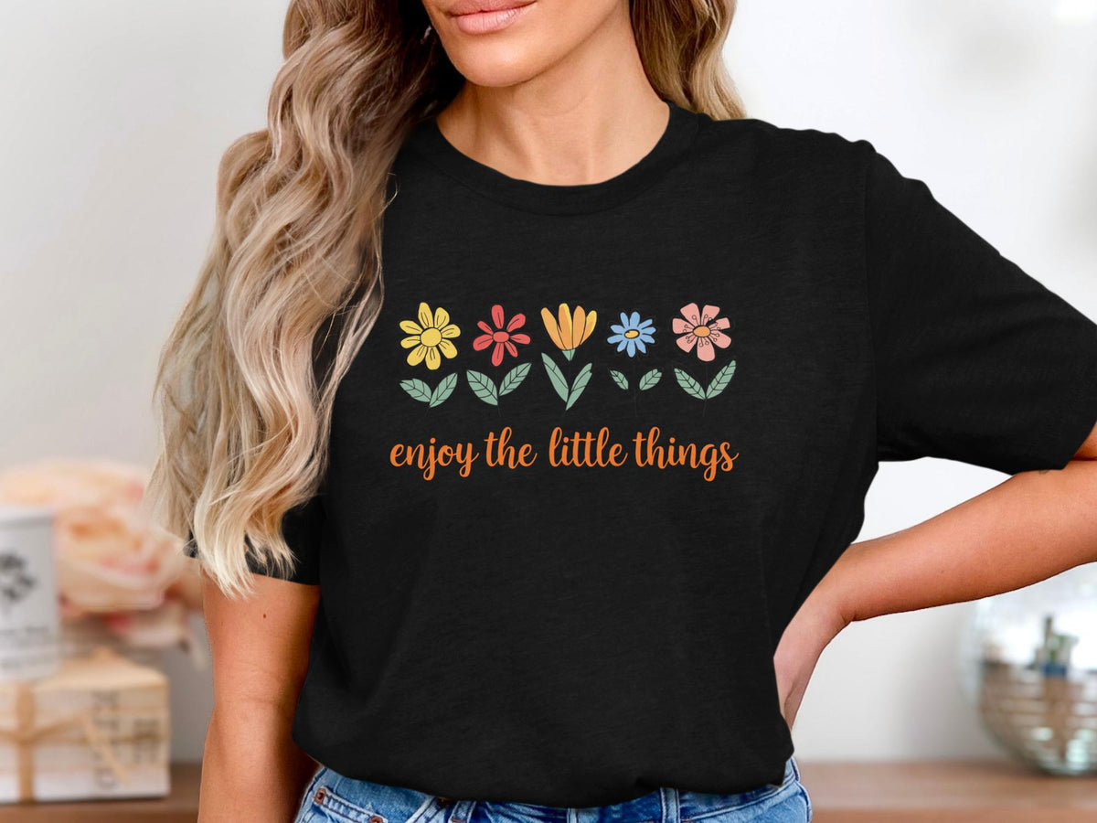 Black t-shirt with colorful flowers and "enjoy the little things" text.