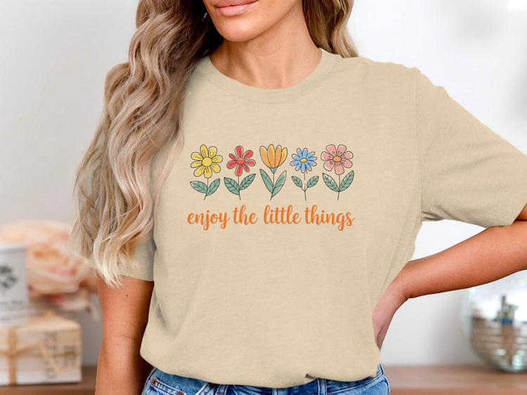 Cream t-shirt with line drawing flowers and "enjoy the little things" text.