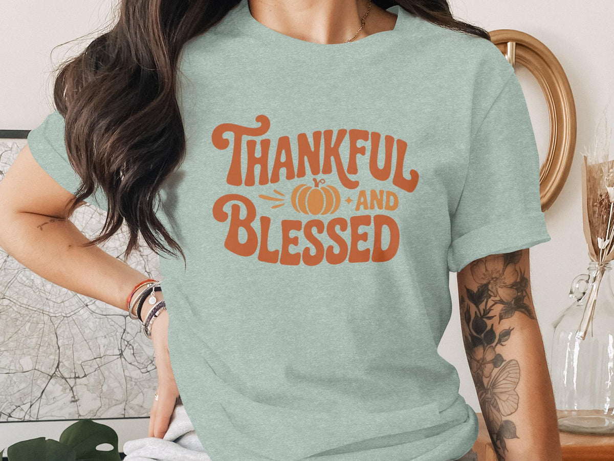 Light blue t-shirt with orange text "Thankful AND Blessed" and a pumpkin illustration.