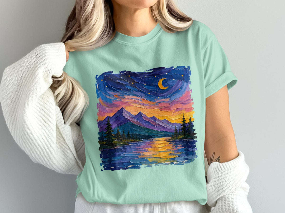 Mint green t-shirt with textured landscape art of mountains, lake, and starry sky.