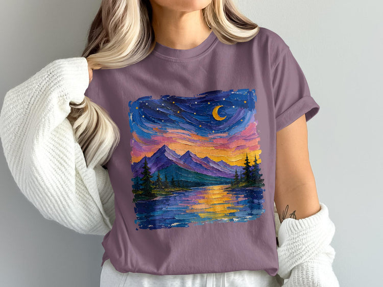 T-shirt with colorful sky, moon, mountains, trees, and water reflection.